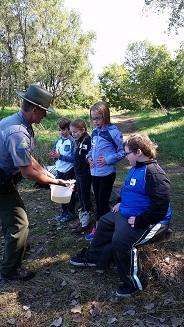 Kids in Outdoor Classroom in Atchison County, Mo - MDC Agent showing kids something from the stream