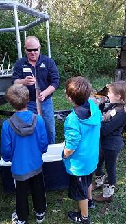 Kids in Outdoor Classroom in Atchison County, Mo - MDC Agent showing kids a fish