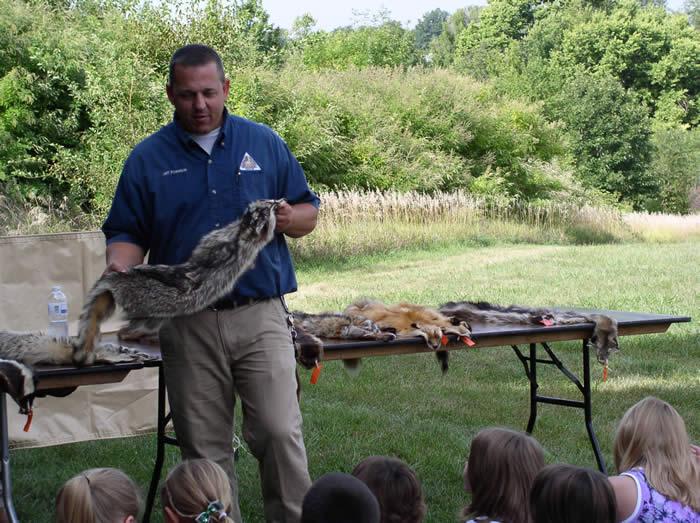 Conservation agent showing students animal skins.