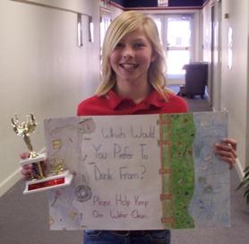 Poster contest winner posing with poster and trophy